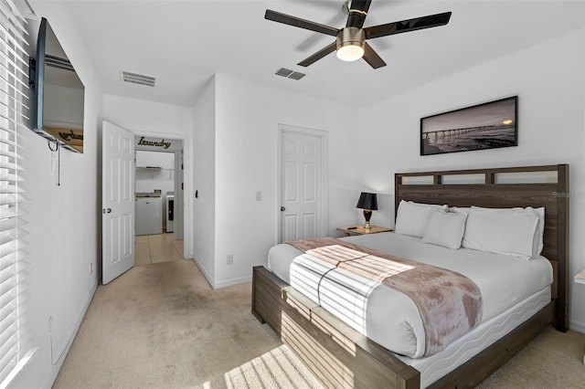 carpeted bedroom with ceiling fan and independent washer and dryer