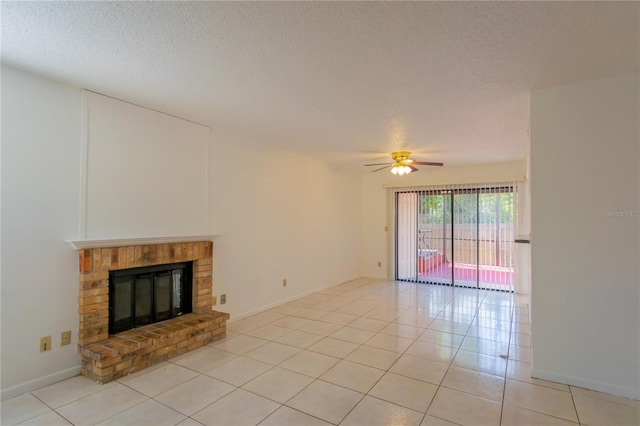 unfurnished living room with light tile patterned flooring, ceiling fan, a textured ceiling, and a brick fireplace