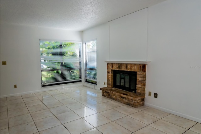 unfurnished living room with a textured ceiling, a fireplace, and light tile patterned floors