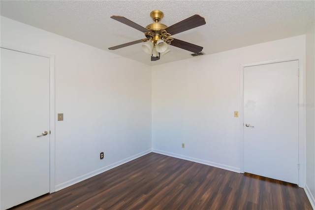 spare room featuring dark wood-type flooring, a textured ceiling, and ceiling fan