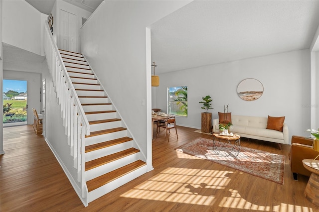 staircase featuring plenty of natural light and light hardwood / wood-style flooring