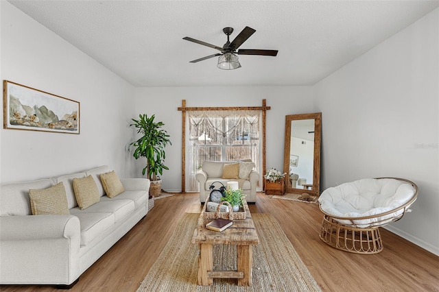 living room featuring ceiling fan and light hardwood / wood-style floors