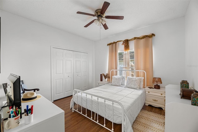 bedroom featuring a closet, a textured ceiling, dark hardwood / wood-style floors, and ceiling fan