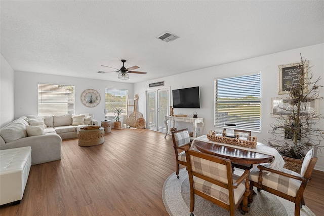 interior space featuring a textured ceiling, ceiling fan, wood-type flooring, and french doors