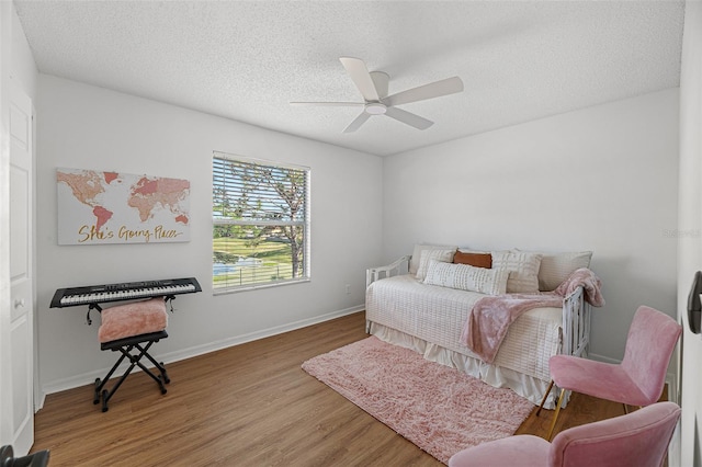 interior space with a textured ceiling, ceiling fan, and hardwood / wood-style flooring