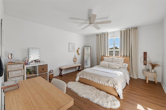 bedroom featuring ceiling fan, a textured ceiling, and wood-type flooring