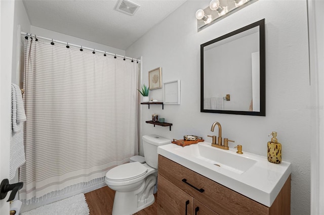 bathroom with vanity, a textured ceiling, wood-type flooring, and toilet