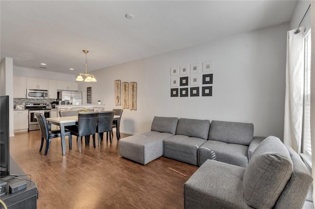 living room featuring plenty of natural light, a notable chandelier, and hardwood / wood-style flooring