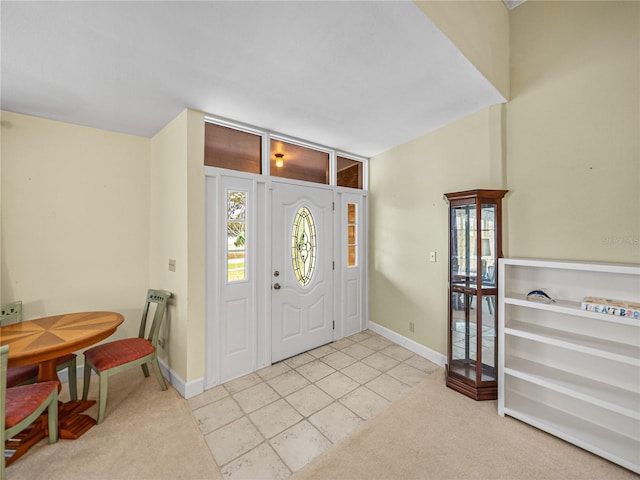 tiled entryway with plenty of natural light and lofted ceiling