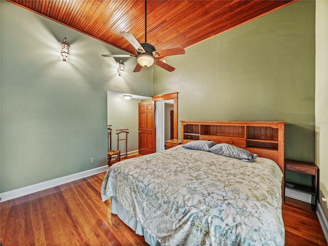 bedroom featuring a high ceiling, ceiling fan, dark wood-type flooring, and wood ceiling