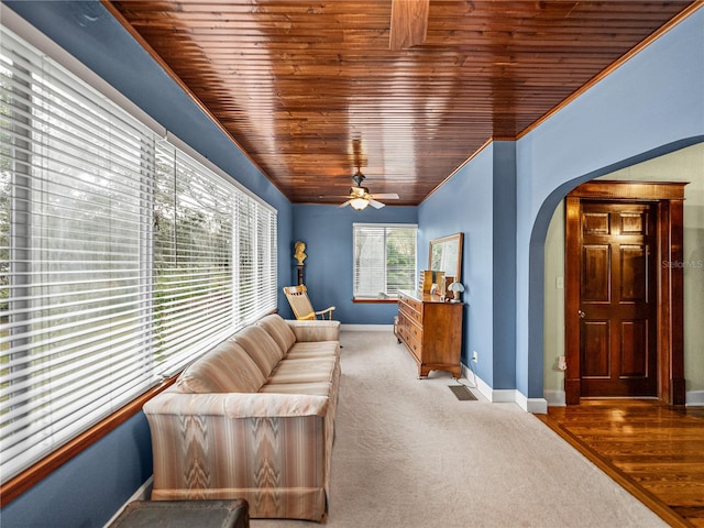 living room with vaulted ceiling, ceiling fan, wooden ceiling, and dark colored carpet