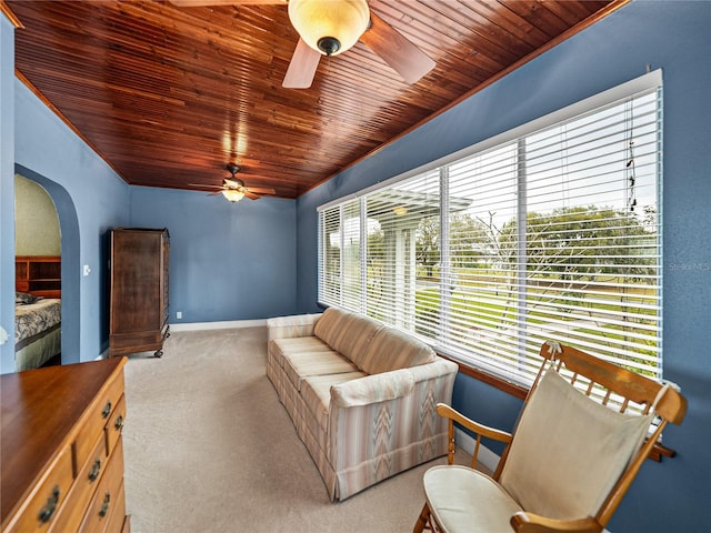 living room with wooden ceiling, ceiling fan, light colored carpet, and a wealth of natural light