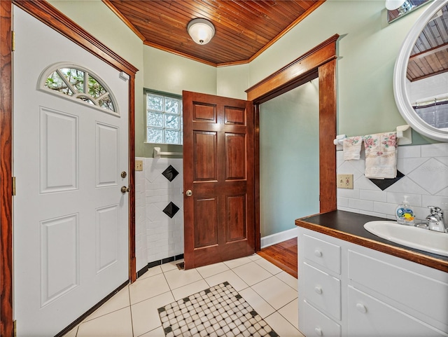 entrance foyer featuring ornamental molding, sink, wooden ceiling, and light hardwood / wood-style flooring