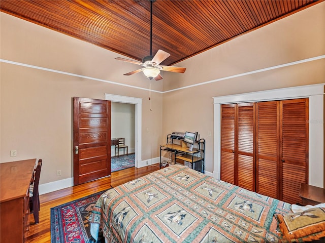 bedroom with a closet, wood ceiling, light hardwood / wood-style floors, and ceiling fan