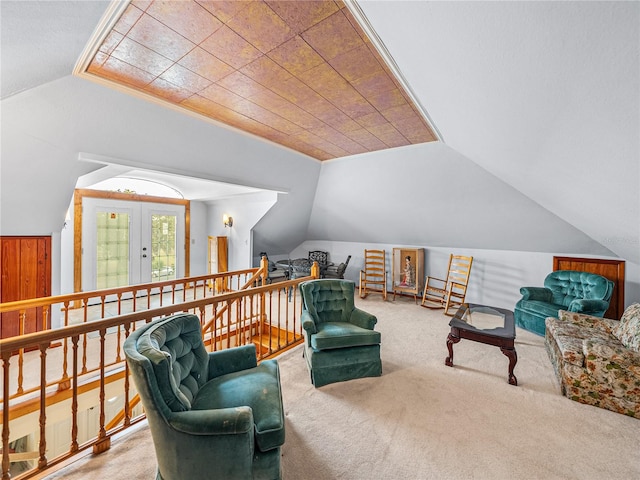 living area with lofted ceiling, light colored carpet, and french doors