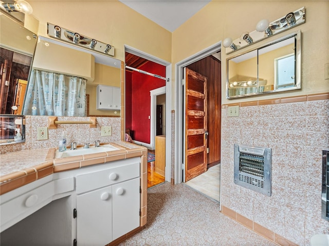 bathroom featuring tasteful backsplash, vanity with extensive cabinet space, and tile flooring