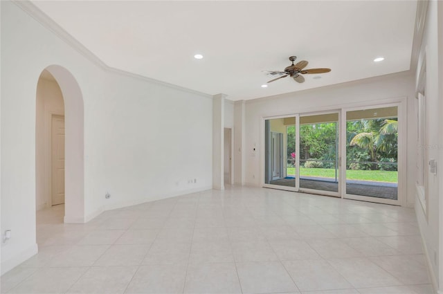 spare room with baseboards, arched walkways, a ceiling fan, ornamental molding, and recessed lighting