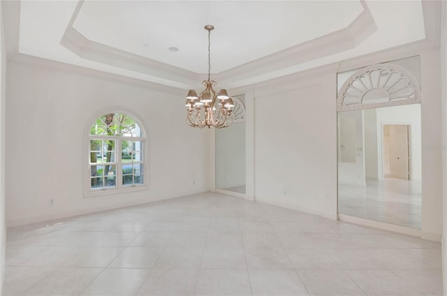 empty room with a tray ceiling, a notable chandelier, and baseboards