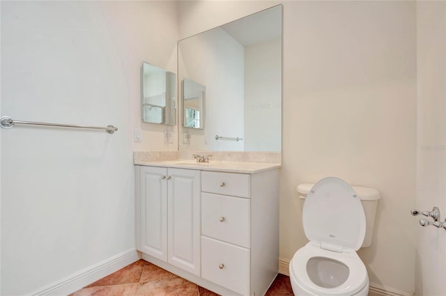 bathroom featuring toilet, tile patterned floors, baseboards, and vanity