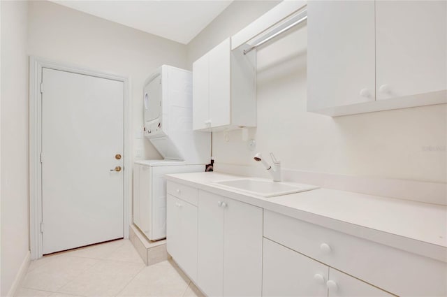 laundry room with cabinet space, stacked washing maching and dryer, light tile patterned floors, and a sink