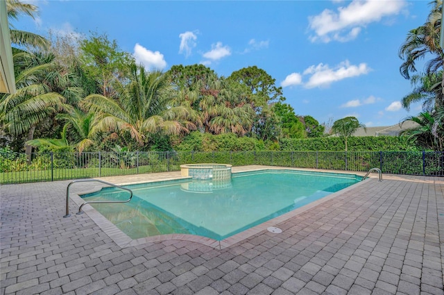 view of swimming pool featuring a patio area, a pool with connected hot tub, and fence