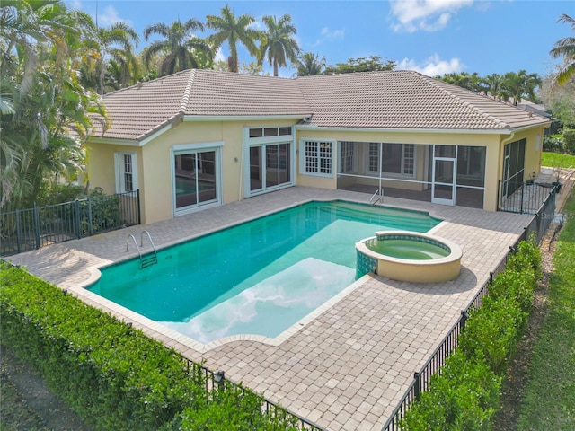 view of pool featuring a sunroom, a patio, fence, and a pool with connected hot tub