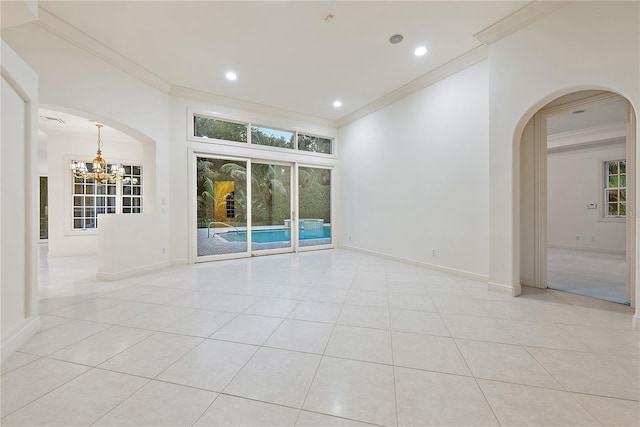 spare room featuring crown molding, light tile patterned flooring, baseboards, and an inviting chandelier