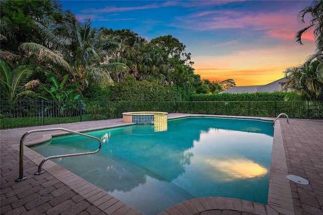 view of pool featuring fence and a pool with connected hot tub