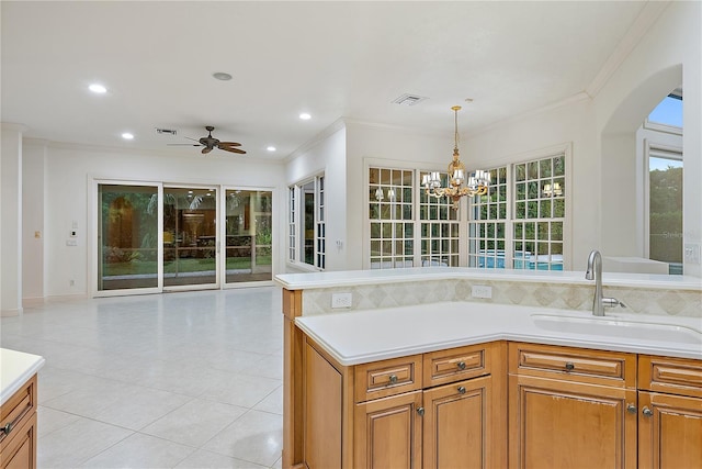 kitchen featuring crown molding, a sink, ceiling fan with notable chandelier, and light countertops