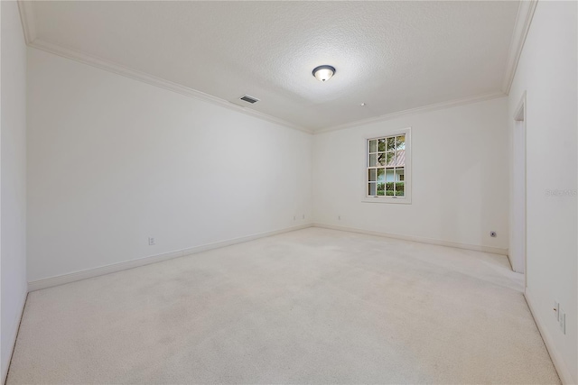 carpeted empty room with a textured ceiling, visible vents, ornamental molding, and baseboards