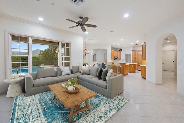 living room with visible vents, arched walkways, crown molding, and recessed lighting