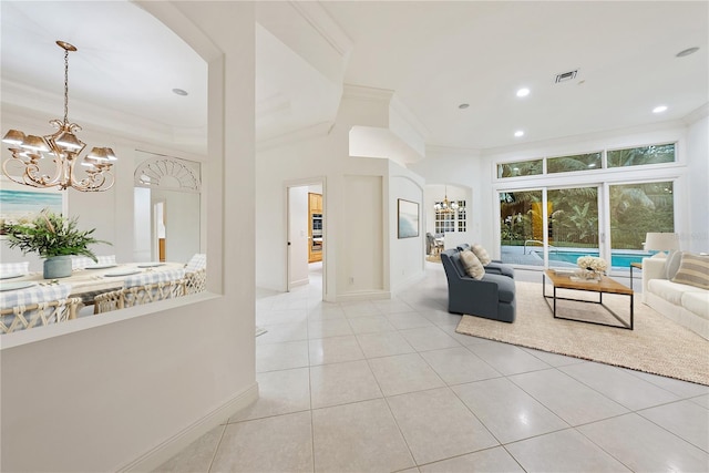 living area featuring arched walkways, a chandelier, ornamental molding, and visible vents