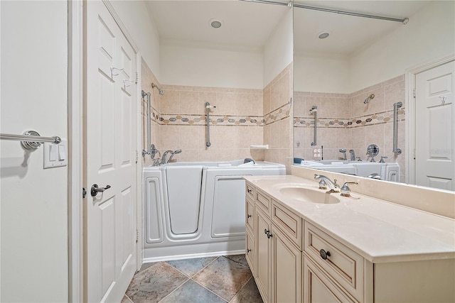 full bathroom with vanity, a shower, a tub, and washing machine and clothes dryer