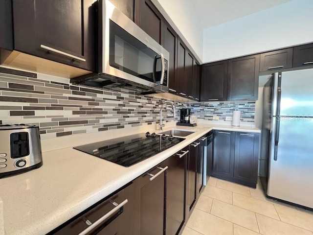 kitchen with sink, light tile floors, backsplash, stainless steel appliances, and dark brown cabinetry