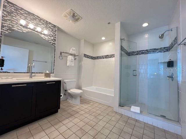 bathroom featuring walk in shower, toilet, vanity, and tile flooring