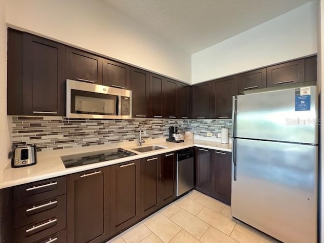 kitchen with backsplash, dark brown cabinetry, appliances with stainless steel finishes, and sink