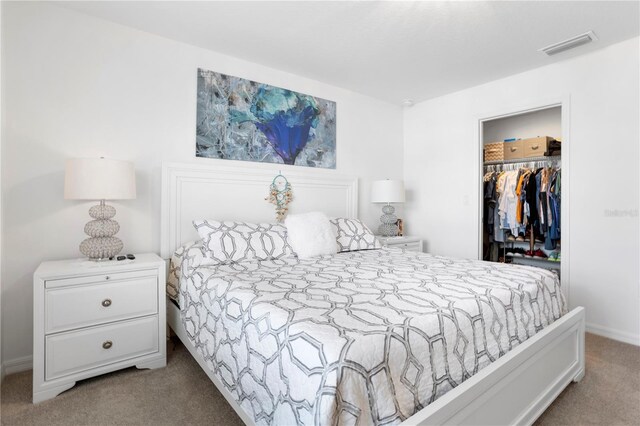 carpeted bedroom with a spacious closet and a closet