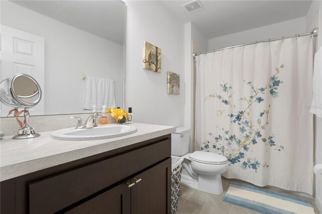 bathroom featuring toilet, large vanity, and tile floors