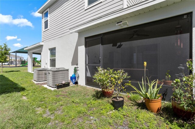 exterior space featuring central air condition unit, a yard, and ceiling fan