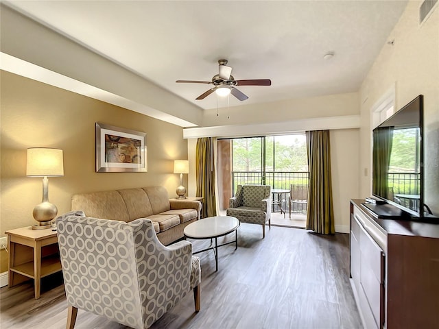 living room with wood-type flooring and ceiling fan