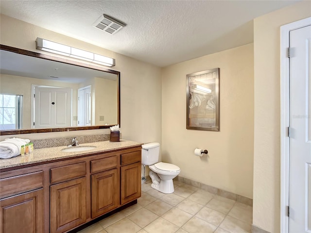 bathroom featuring vanity, a textured ceiling, tile floors, and toilet