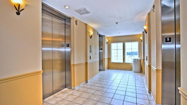 kitchen featuring elevator and light tile flooring