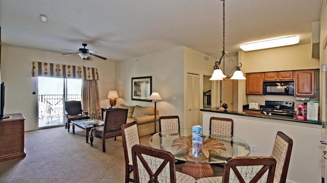 carpeted dining area featuring a textured ceiling and ceiling fan with notable chandelier