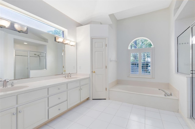 bathroom with tile floors, large vanity, independent shower and bath, and double sink