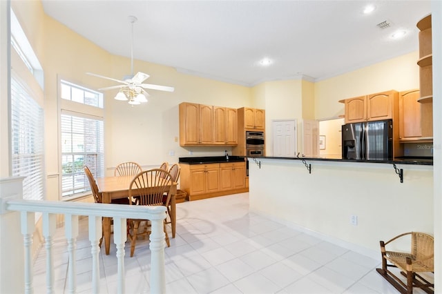 kitchen with stainless steel appliances, ceiling fan, light tile flooring, and light brown cabinets