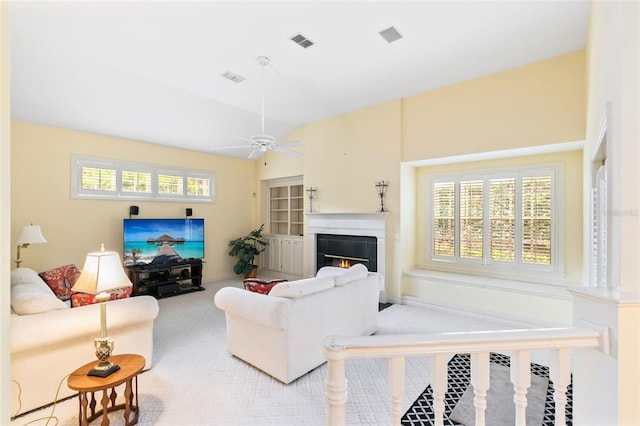 carpeted living room featuring a tiled fireplace and ceiling fan