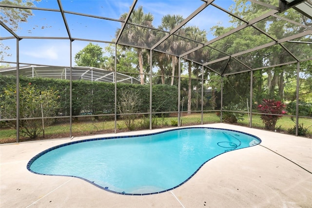 view of swimming pool with glass enclosure and a patio