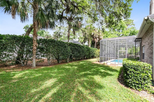 view of yard with glass enclosure and a fenced in pool