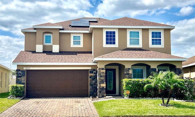 view of front of home featuring solar panels, a garage, and a front lawn