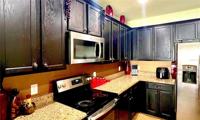 kitchen with stainless steel appliances and light stone counters